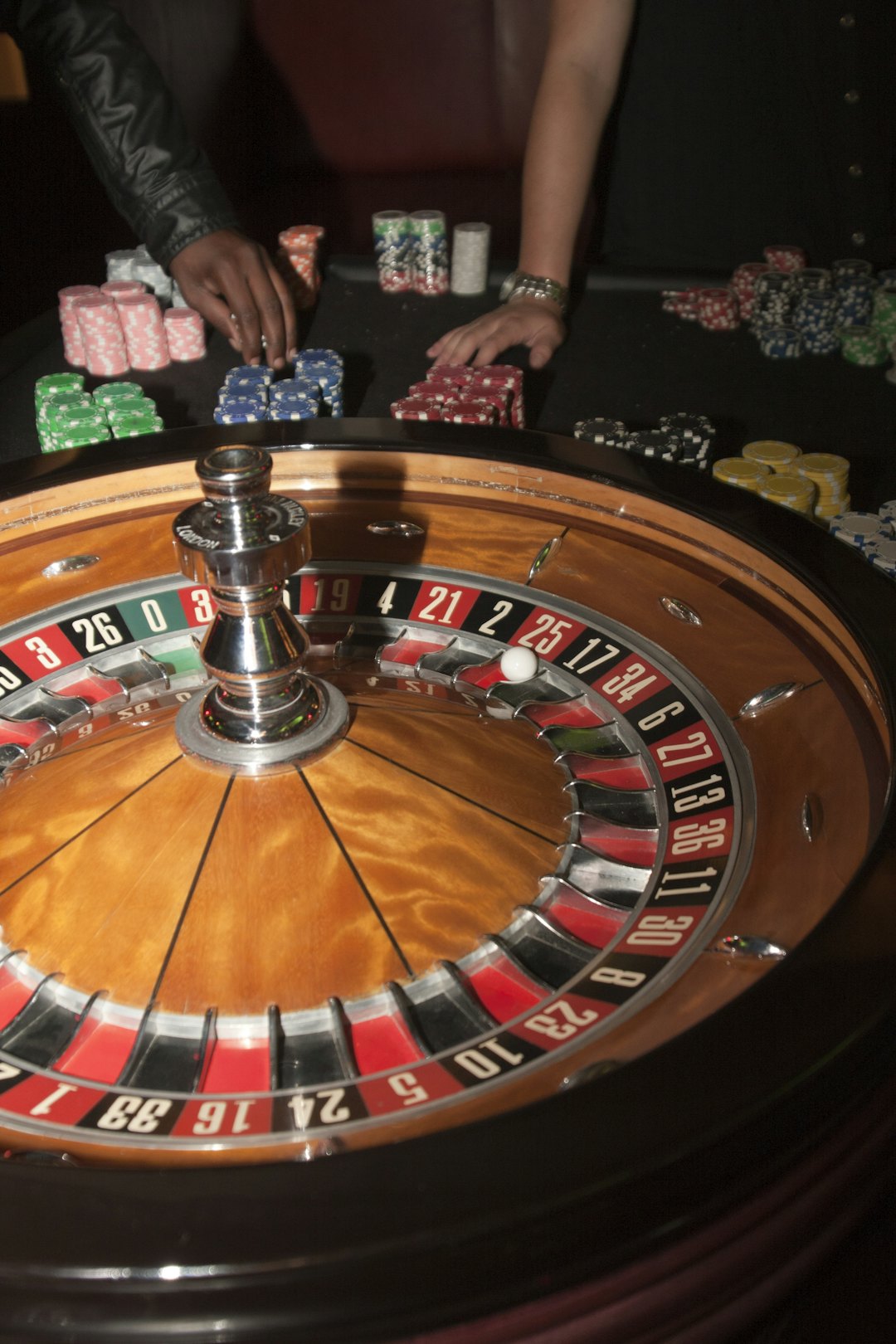 Roda roulette dengan angka merah dan hitam di meja kasino