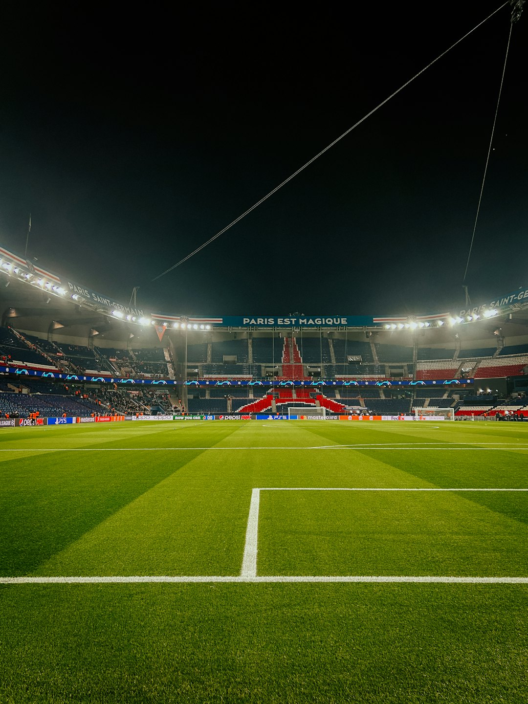 Lapangan sepak bola malam hari dengan lampu stadion menyala